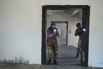 Image showing A group of professional soldiers bravely executes a dangerous rescue mission, surrounded by fire in a perilous building.