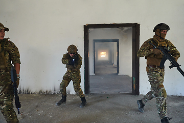 Image showing A group of professional soldiers bravely executes a dangerous rescue mission, surrounded by fire in a perilous building.