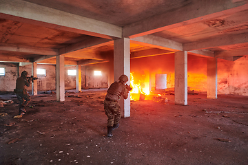 Image showing A group of professional soldiers bravely executes a dangerous rescue mission, surrounded by fire in a perilous building.