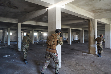 Image showing A group of professional soldiers bravely executes a dangerous rescue mission, surrounded by fire in a perilous building.