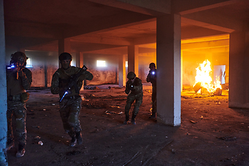 Image showing A group of professional soldiers bravely executes a dangerous rescue mission, surrounded by fire in a perilous building.