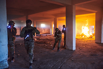 Image showing A group of professional soldiers bravely executes a dangerous rescue mission, surrounded by fire in a perilous building.