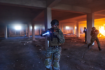 Image showing A group of professional soldiers bravely executes a dangerous rescue mission, surrounded by fire in a perilous building.