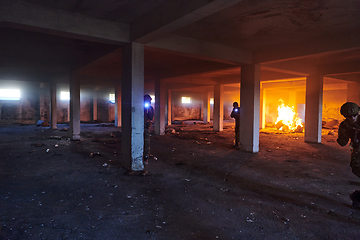 Image showing A group of professional soldiers bravely executes a dangerous rescue mission, surrounded by fire in a perilous building.