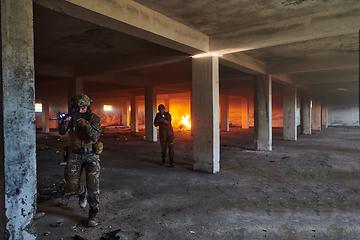 Image showing A group of professional soldiers bravely executes a dangerous rescue mission, surrounded by fire in a perilous building.