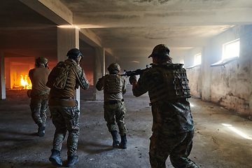 Image showing A group of professional soldiers bravely executes a dangerous rescue mission, surrounded by fire in a perilous building.