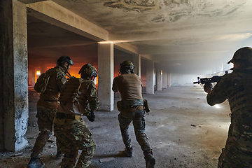 Image showing A group of professional soldiers bravely executes a dangerous rescue mission, surrounded by fire in a perilous building.