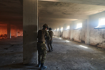 Image showing A group of professional soldiers bravely executes a dangerous rescue mission, surrounded by fire in a perilous building.