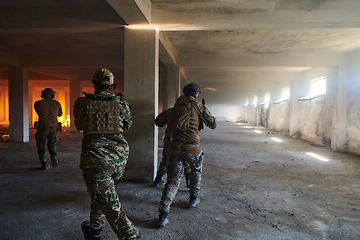 Image showing A group of professional soldiers bravely executes a dangerous rescue mission, surrounded by fire in a perilous building.