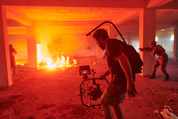 Image showing A professional cameraman captures the intense moments as a group of skilled soldiers embarks on a dangerous mission inside an abandoned building, their actions filled with suspense and bravery