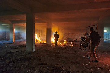 Image showing A professional cameraman captures the intense moments as a group of skilled soldiers embarks on a dangerous mission inside an abandoned building, their actions filled with suspense and bravery