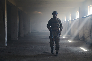 Image showing A professional soldier in an abandoned building shows courage and determination in a war campaign