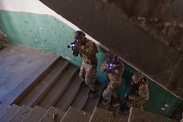 Image showing A group of professional soldiers bravely executes a dangerous rescue mission, surrounded by fire in a perilous building.