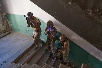 Image showing A group of professional soldiers bravely executes a dangerous rescue mission, surrounded by fire in a perilous building.