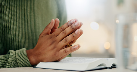 Image showing Home, closeup and person with hands, praying and bible with faith, guidance and religion. Zoom, man and guy with holy book, scripture or prayer with spirit, believe or Christian with worship or peace