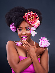 Image showing My secret is out. Studio shot of a beautiful young woman posing with flowers in her hair.