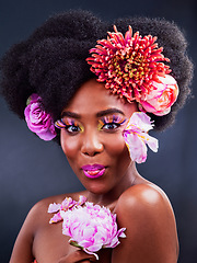 Image showing Why fit in when makeup can make you stand out. Studio shot of a beautiful young woman posing with flowers in her hair.