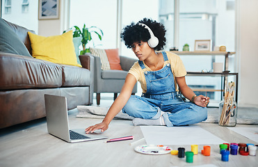 Image showing I blog about my art. a young woman using her laptop while sitting at home with paint and a blank canvas.