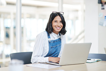 Image showing Im getting so much done today. Portrait of a young businesswoman using a laptop in an office.