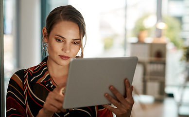 Image showing Tapped into her target audience. a young businesswoman using a digital tablet in a modern office.