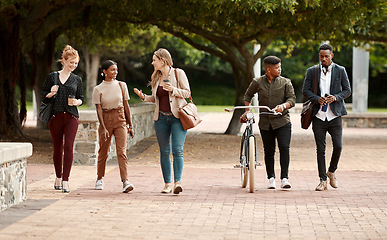 Image showing Success belongs to the willing. a group of young businesspeople chatting while walking through the city.