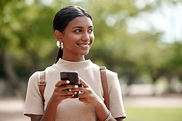 Image showing Progress happens when you keep your thoughts positive. a young businesswoman using a smartphone against a city background.