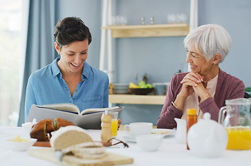 Image showing Should we try this recipe next. a happy senior woman sitting and having breakfast with her attractive young daughter while at home.