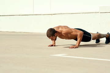 Image showing No one will push you, thats your job. a sporty young man doing pushups as part of his exercise routine.