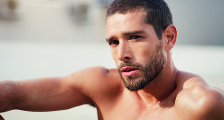 Image showing Quitting does not exist in my vocabulary. Cropped portrait of a handsome shirtless young sportsman taking a break after a workout outdoors.