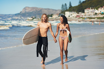 Image showing Shes someone I can be myself with. a young couple spending the day at the beach with their surfboards.