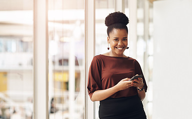 Image showing Im always connected. Cropped portrait of an attractive young businesswoman using her cellphone while standing in the office.