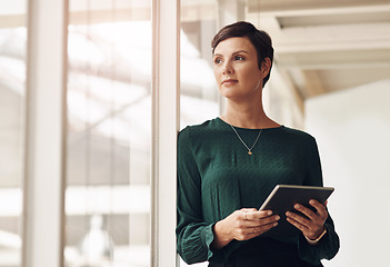 Image showing The ideas are starting to form. an attractive young businesswoman looking thoughtful while using a tablet in her office.