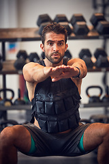 Image showing You are stronger than your challenges. a handsome young man doing squats while working out in the gym.