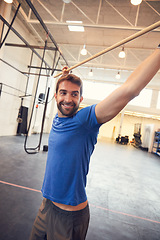 Image showing Sculpting the perfect body with high-intensity workouts. a handsome young man working out with a stick in the gym.