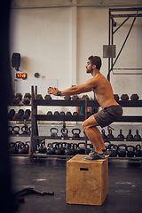 Image showing Its about maintaining proper form. Full length shot of a handsome young man box jumping while working out in the gym.