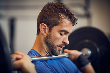 Image showing Train insane or remain the same. a handsome young man lifting weights while working out in the gym.