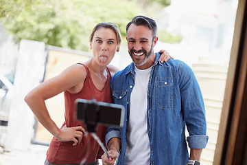 Image showing He brings out her silly side. an affectionate couple taking a selfie together with a selfie stick outdoors.