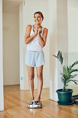 Image showing Ive lost that last bunch of pounds. Full length shot of an attractive young woman looking ecstatic while standing on a weight scale.