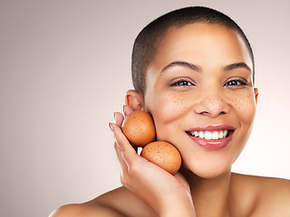 Image showing The high protein content help in repairing tissues and firming skin. Studio shot of a beautiful young woman holding eggs against her face.