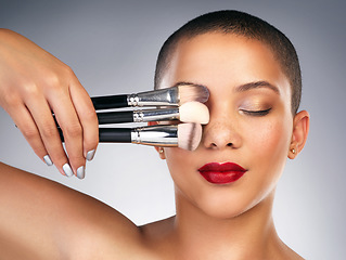 Image showing Never brush in a rush. Studio shot of a beautiful young woman posing with a set of makeup brushes.