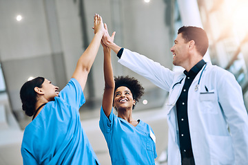 Image showing We save lives when we work together. a diverse team of doctors giving each other a high five in a hospital.