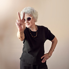 Image showing Nothing’s more cool than old school. a cool senior woman wearing sunglasses and showing a peace gesture.