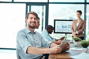 Image showing Proud of his career. Portrait of a young businessman using a digital tablet with his colleagues in the background.