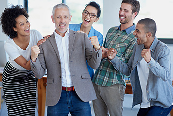 Image showing Teamwork made this happen. a group of happy coworkers celebrating standing in an office.