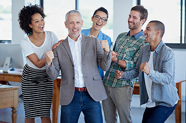Image showing Another business success story. a group of happy coworkers celebrating standing in an office.