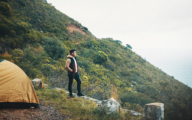 Image showing Never lose an opportunity to see something beautiful. a young man admiring the view while camping on a mountain.