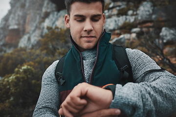 Image showing So much world, so little time. a young man checking the time while out on a hike.