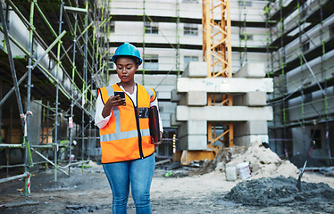 Image showing Client satisfaction under construction. a young woman using a smartphone while working at a construction site.