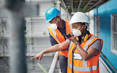 Image showing Construction expertise that rises above the rest. a young woman using a walkie talkie while working with her colleague at a construction site.