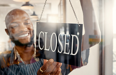 Image showing Another day done and dusted. a young business owner hanging up a closed for business sign.